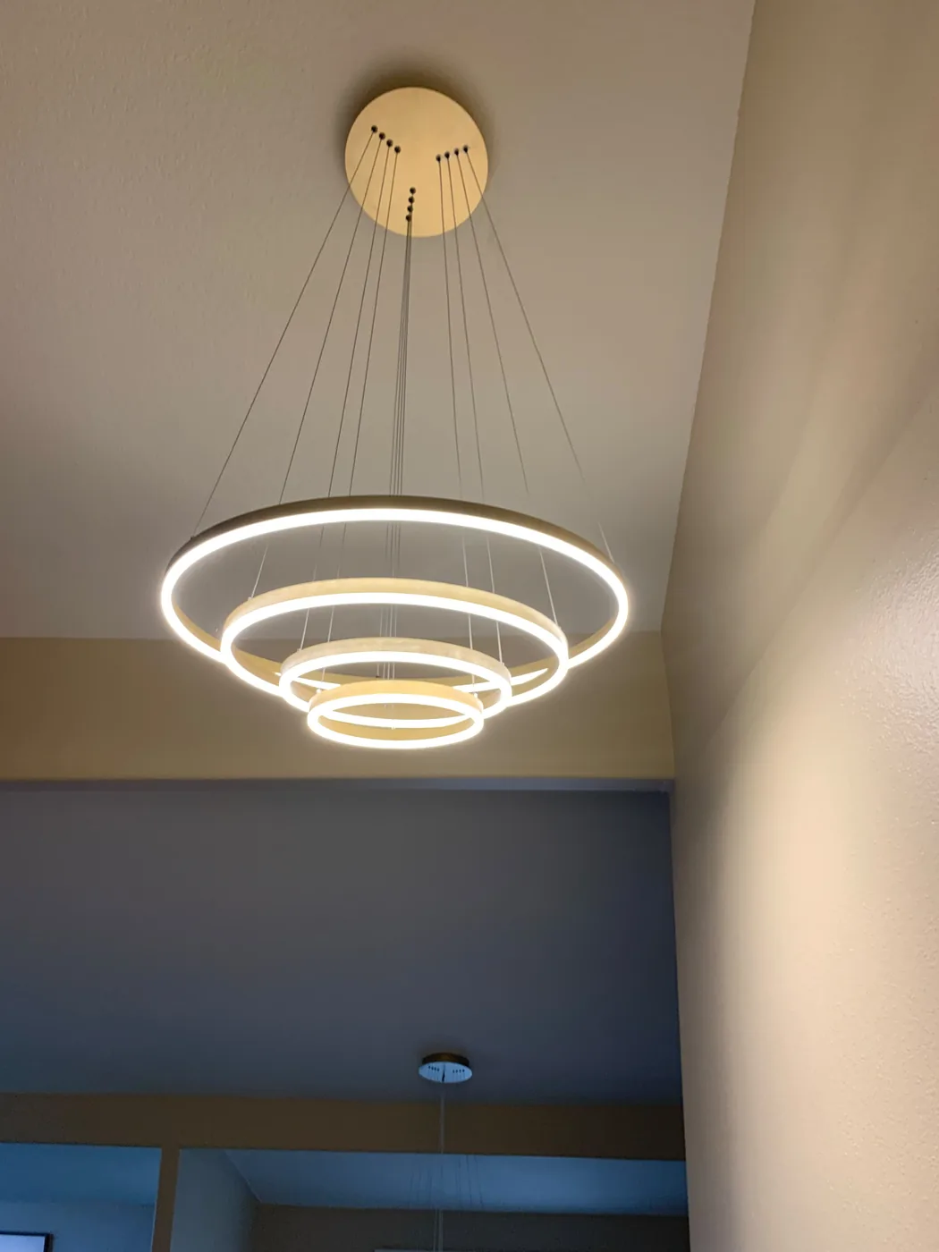 Modern illuminated ring pendant installed in a high ceiling